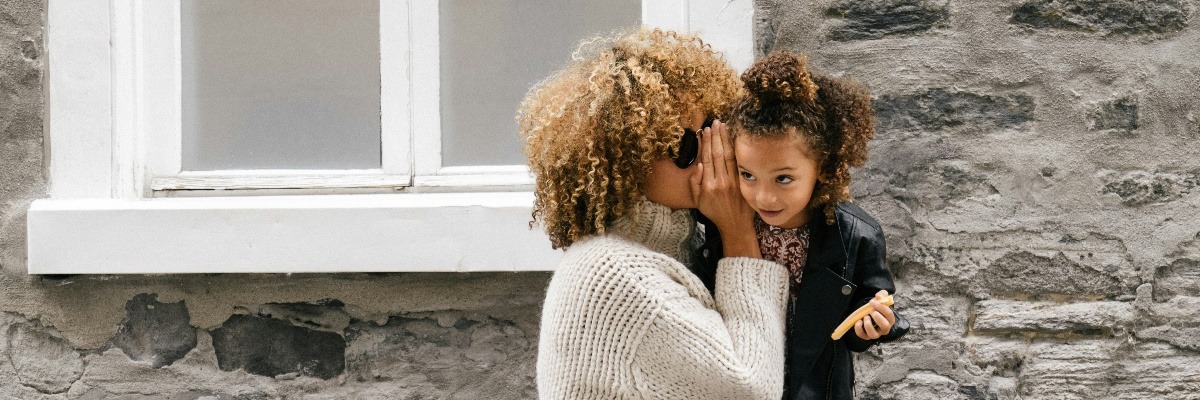 Woman whispering in daughter's ear