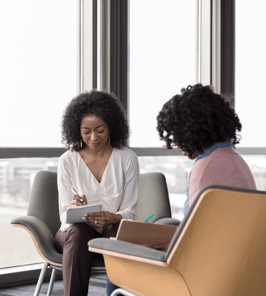 two-women-taking-notes-in-chairs